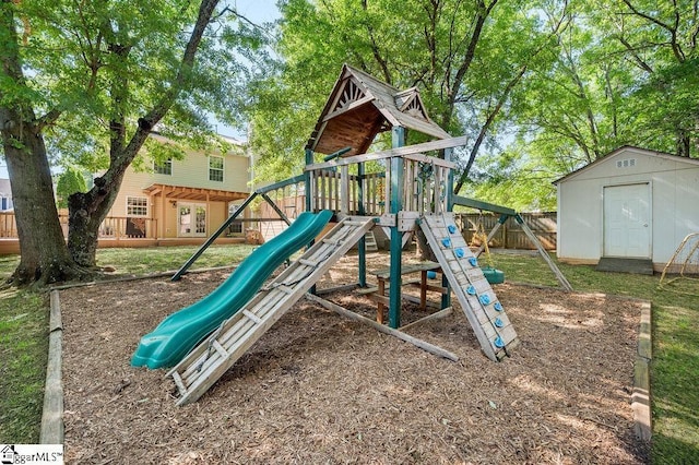 view of playground featuring an outbuilding, fence, and a storage shed
