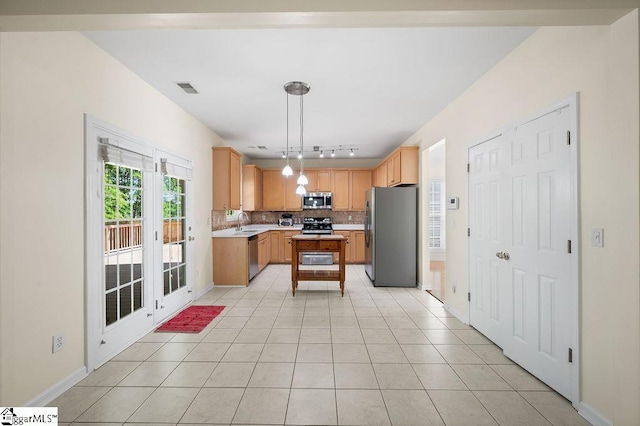 kitchen with track lighting, light countertops, a sink, backsplash, and stainless steel appliances