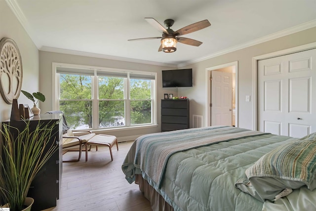 bedroom with crown molding, ceiling fan, visible vents, and hardwood / wood-style flooring