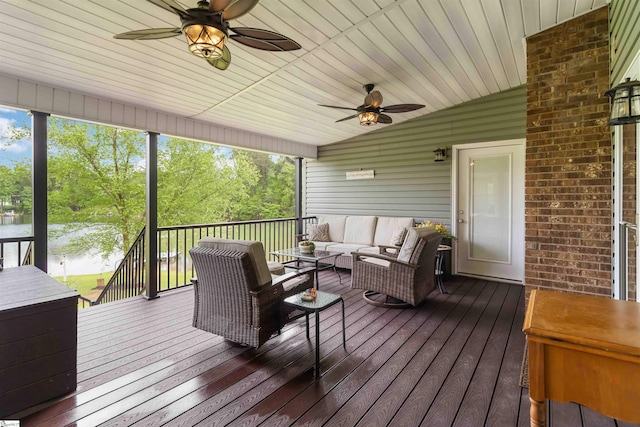 wooden deck with an outdoor living space, a ceiling fan, and a water view