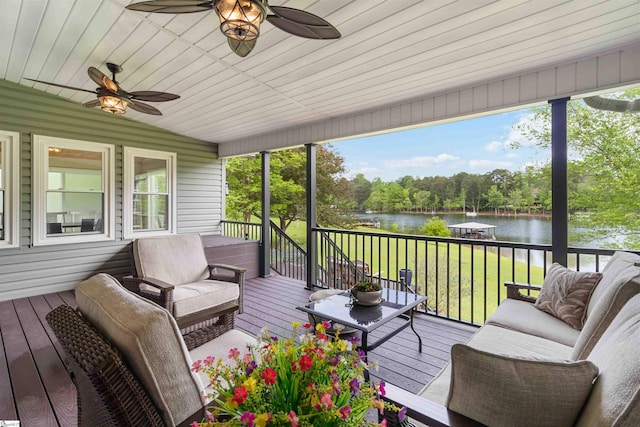 wooden terrace with a lawn, a water view, and ceiling fan