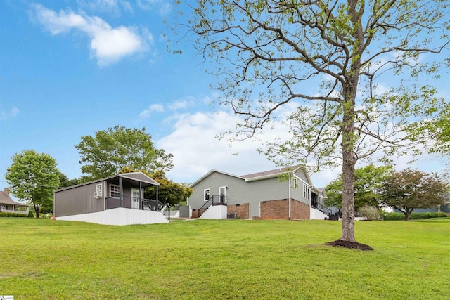 back of house with a lawn and brick siding