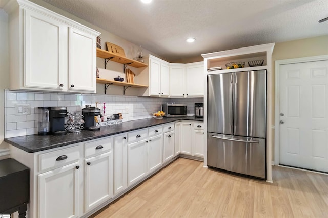 kitchen featuring light wood-style floors, open shelves, white cabinets, and stainless steel appliances
