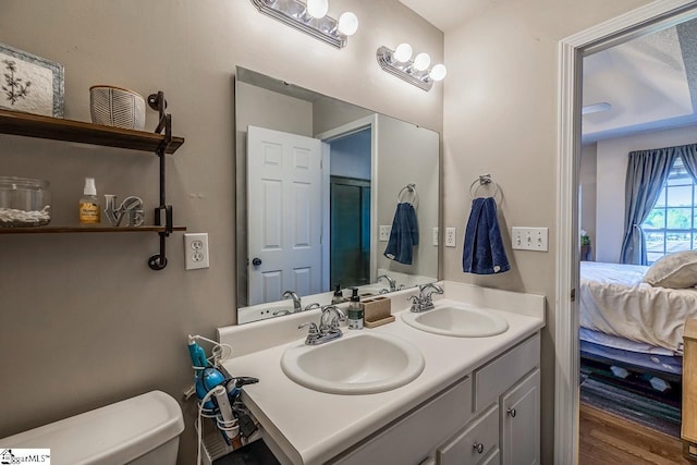 ensuite bathroom with a sink, toilet, ensuite bath, and double vanity