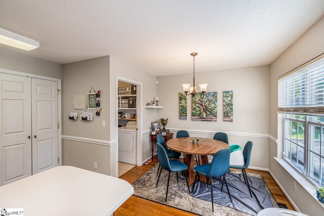 dining area featuring a textured ceiling, a notable chandelier, and wood finished floors
