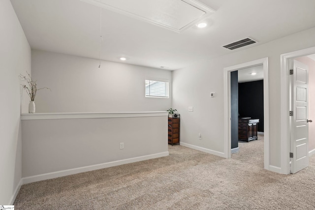 empty room with carpet floors, attic access, recessed lighting, baseboards, and visible vents
