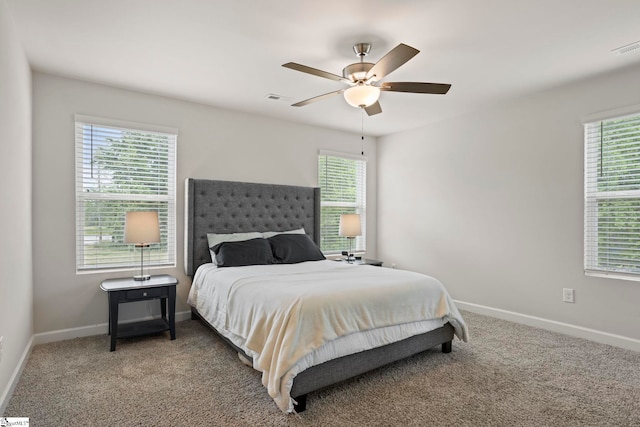 carpeted bedroom with baseboards, visible vents, and multiple windows