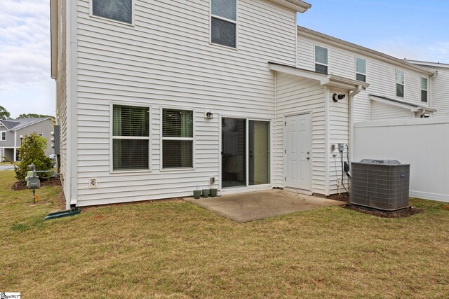 back of property featuring central air condition unit, fence, a yard, and a patio area