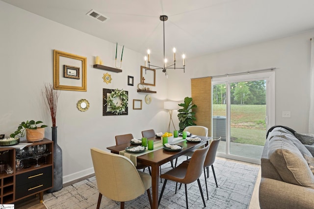dining room with visible vents, baseboards, a notable chandelier, and light wood-type flooring