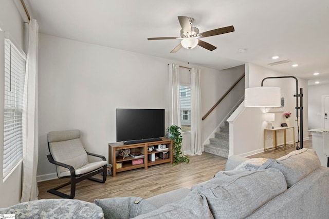 living area with ceiling fan, visible vents, wood finished floors, stairway, and recessed lighting