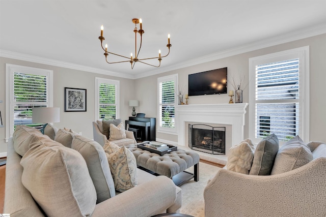 living room featuring ornamental molding, a fireplace with raised hearth, and a notable chandelier