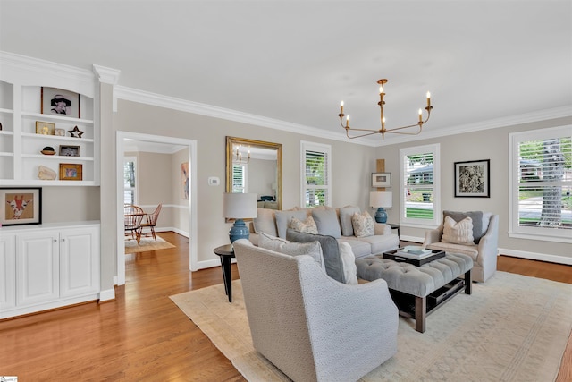 living room featuring an inviting chandelier, baseboards, crown molding, and light wood-style flooring