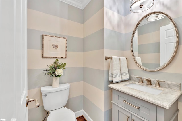 bathroom with toilet, ornamental molding, and vanity