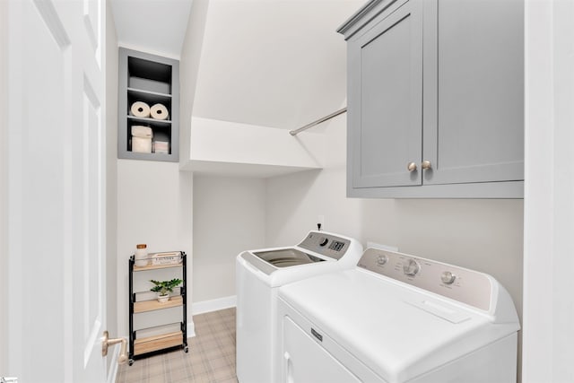 washroom featuring cabinet space, baseboards, washing machine and dryer, and light floors