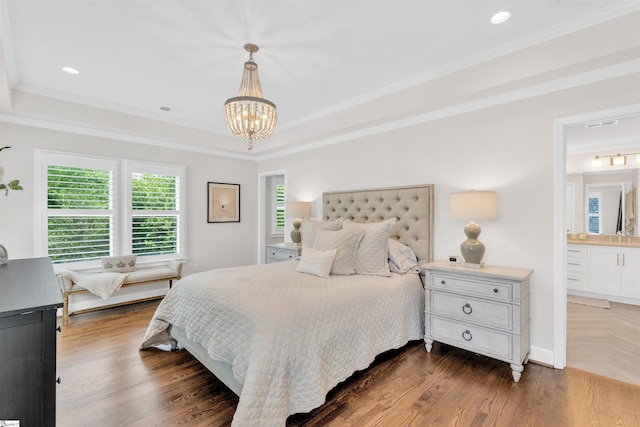bedroom featuring dark wood finished floors, a raised ceiling, a chandelier, and visible vents