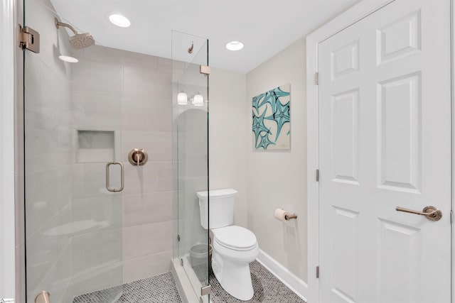bathroom with baseboards, tile patterned floors, a stall shower, and toilet