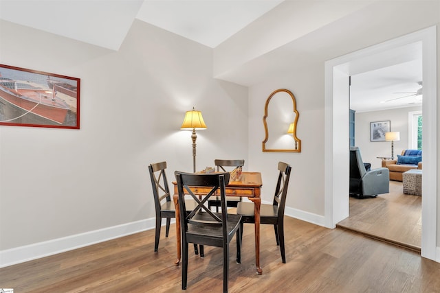 dining space featuring baseboards, ceiling fan, and wood finished floors