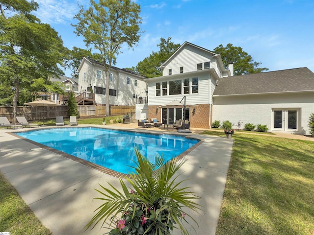 view of pool featuring french doors, fence, a fenced in pool, and a yard