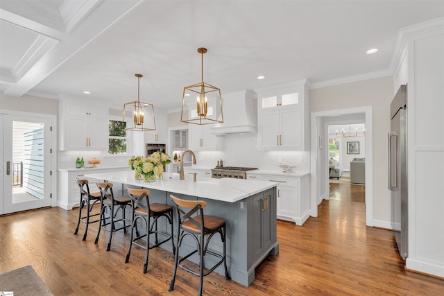 kitchen featuring a sink, appliances with stainless steel finishes, plenty of natural light, and custom exhaust hood