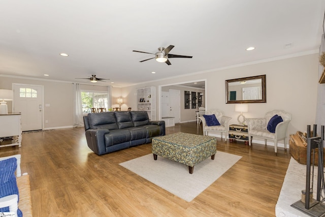 living area featuring crown molding, a ceiling fan, baseboards, and recessed lighting