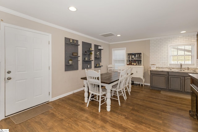 dining room with visible vents, wood finished floors, baseboards, ornamental molding, and recessed lighting