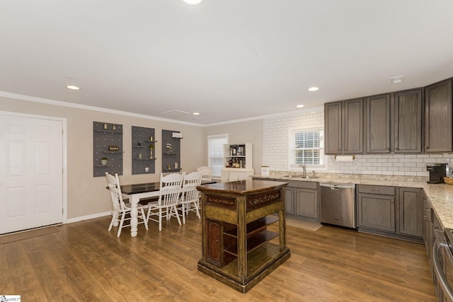 kitchen with stainless steel dishwasher, a sink, dark wood finished floors, and crown molding