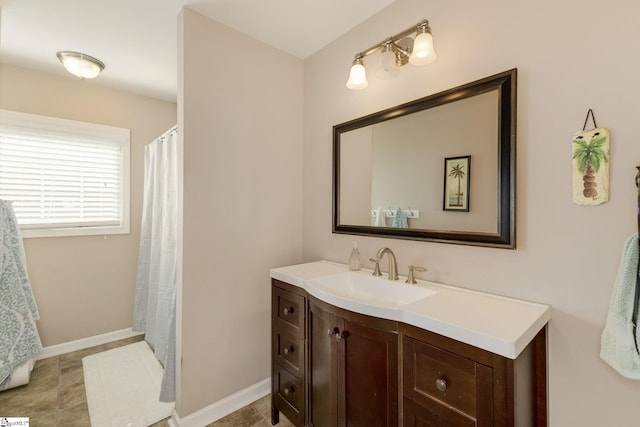 full bathroom featuring baseboards and vanity