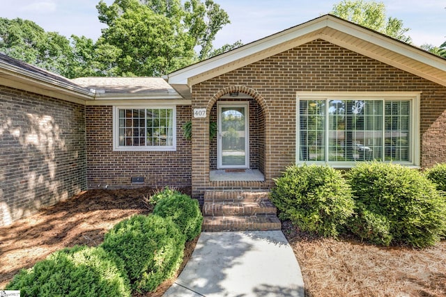 property entrance with brick siding and crawl space