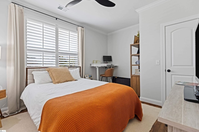 bedroom featuring a ceiling fan, visible vents, crown molding, baseboards, and light wood-style flooring