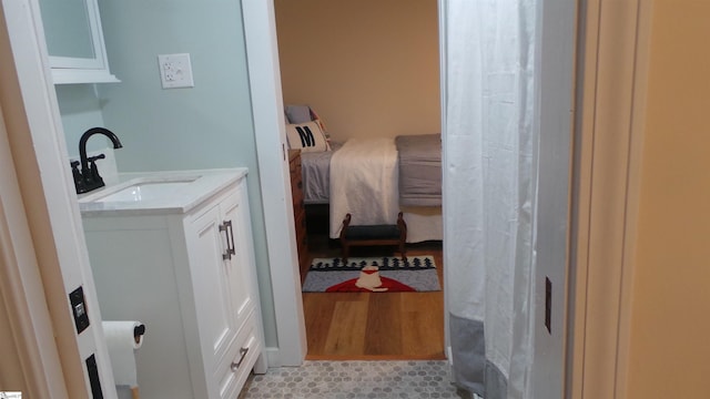 ensuite bathroom featuring vanity, wood finished floors, and ensuite bath