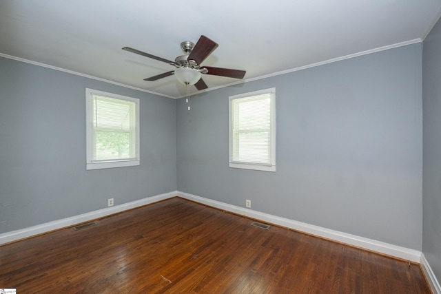 empty room with crown molding, baseboards, visible vents, and dark wood-type flooring