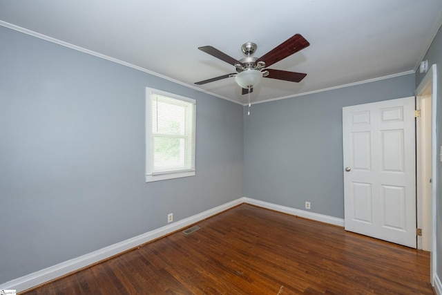 spare room featuring visible vents, ornamental molding, wood finished floors, baseboards, and ceiling fan