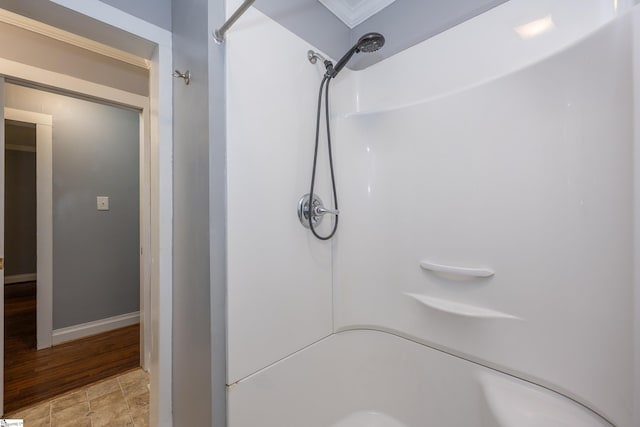 bathroom featuring baseboards and a shower