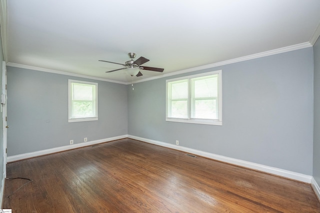 empty room with a ceiling fan, visible vents, crown molding, dark wood finished floors, and baseboards