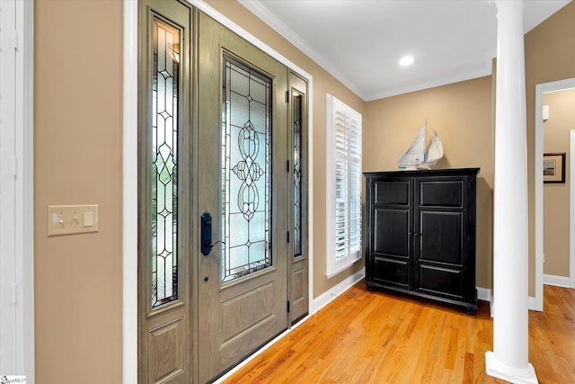 foyer entrance with baseboards, ornamental molding, decorative columns, and light wood finished floors
