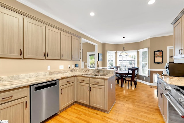 kitchen featuring light brown cabinetry, appliances with stainless steel finishes, a sink, light wood-style flooring, and a peninsula