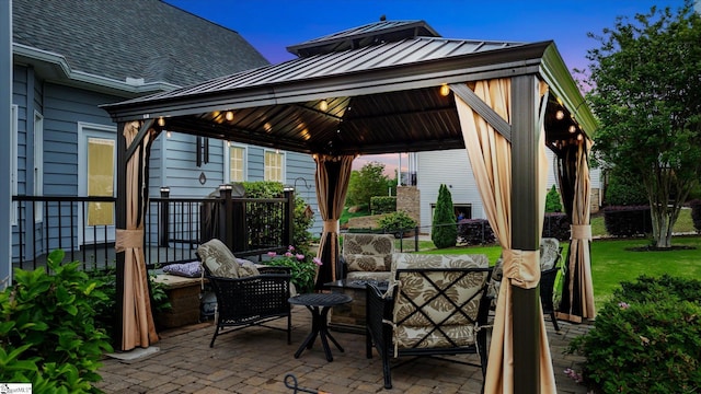 patio terrace at dusk with a gazebo and an outdoor hangout area