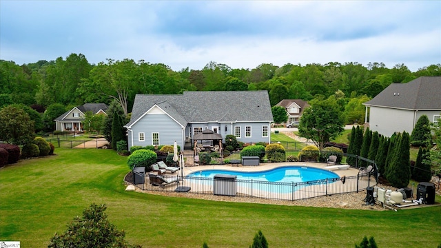 view of swimming pool featuring a lawn, fence, a fenced in pool, and a gazebo