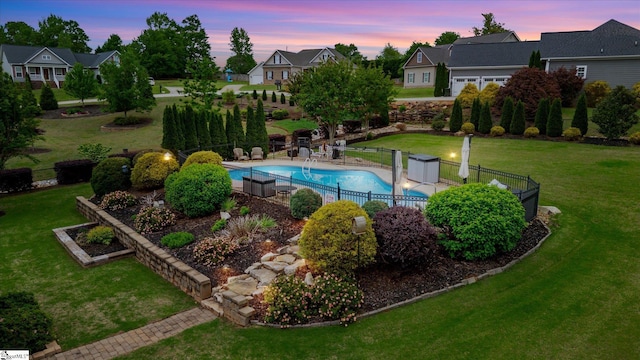 view of swimming pool with fence, a fenced in pool, a yard, and a residential view