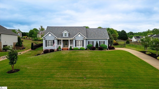 cape cod home featuring a front lawn, fence, and driveway