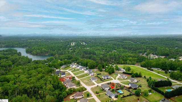 birds eye view of property with a water view and a wooded view