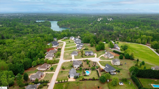 drone / aerial view featuring a water view, a residential view, and a wooded view