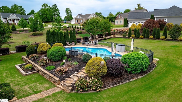 view of swimming pool featuring fence, a fenced in pool, a yard, and a residential view