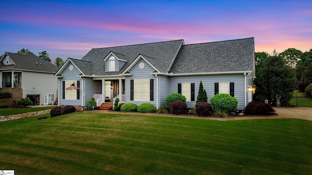 new england style home featuring a yard and a shingled roof