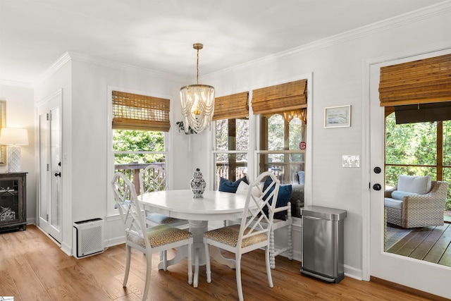 dining room featuring baseboards, a notable chandelier, ornamental molding, and light wood-style flooring