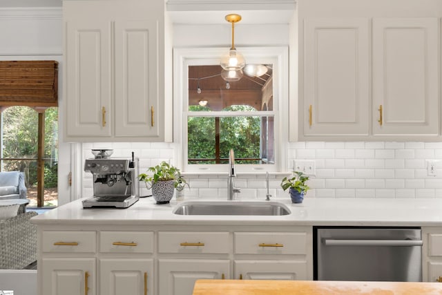 kitchen featuring a sink, backsplash, dishwasher, and white cabinets