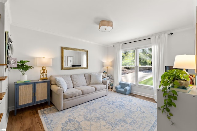 living room with crown molding, baseboards, and wood finished floors