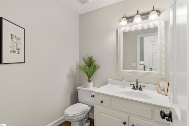 bathroom with toilet, visible vents, and vanity