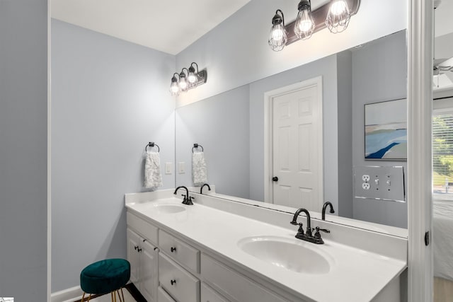 bathroom featuring a sink, baseboards, and double vanity