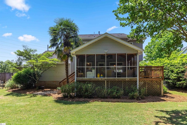 rear view of house with a lawn and a sunroom
